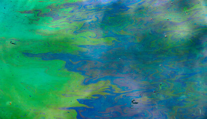 Fototapeta na wymiar Toxic colours of oil and water in a chemical spill creating a psychedelic blur of rainbow colours. Copyspace area for environmental and pollution based themes and designs.