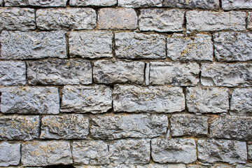 Ancient wall with stone blocks in the form of bricks