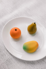 cakes in the form of fruits on a white plate