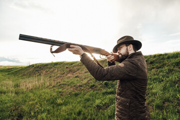 Vintage hunter walks. Rifle Hunter Silhouetted in Beautiful Sunset or Sunrise. Hunter aiming rifle...