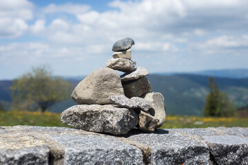 Closeup of stone balance on stoned wall on mountain landscape background