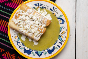 Mexican drowned flautas with green sauce also called 