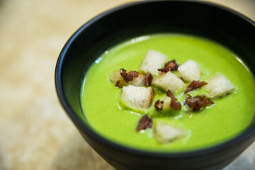 cream soup with green peas served in a deep plate