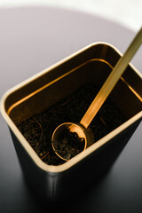 Golden spoon with leaf tea on the table