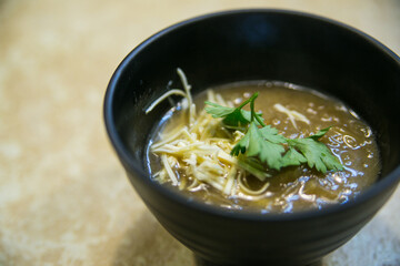 French onion soup with breadcrumbs and cheese served in a clay plate
