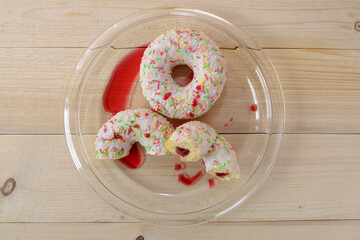 bright glazed donuts with topping and sprinkles on a plate flatlay