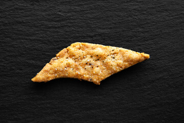 One cookie with salt. Crackers with cheese on a black background.