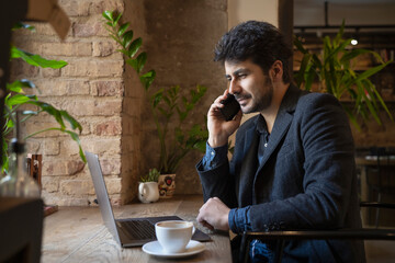 Brunette man talking with phone in cafe