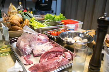 meat eggs and other products in metal bowls prepared for cooking in a professional kitchen