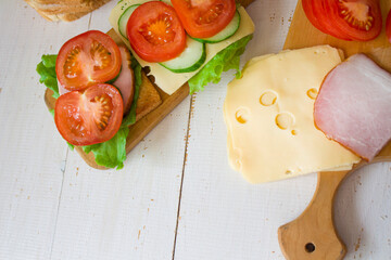 Cheese and ham toasts. Tomatoes and greens. Healthy eating concept. Banner. copyspace.