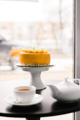 yellow mousse cake with meringue on a black table