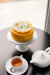 yellow mousse cake with meringue on a black table