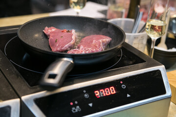 raw steak is fried in a pan in the kitchen