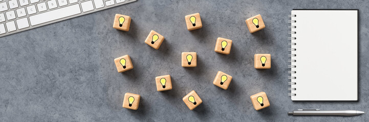 cubes with lightbulb symbols and a keyboard on concrete background