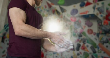 Young bearded athlete clapping hands with chalk powder preparing for training