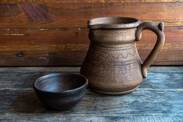 Ceramic jug and ceramic bowl on a rustic wooden table.