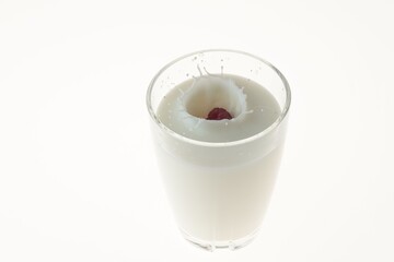 Close up view of red raspberry falling into milk on a white background.