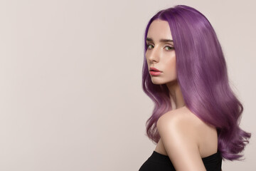 Fototapeta premium portrait of a woman with luxurious lilac hair on a gray background. Bright hair