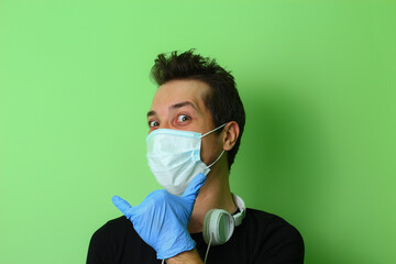 Expressive young man or guy on a light green background. Trick emotion
