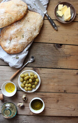 Fototapeta na wymiar Ciabatta. Fresh italian ciabatta bread with herbs, olive oil and olives on grey background, top view, copy space.
