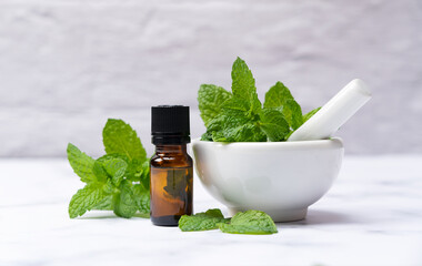 Mint essential oil and mint leaves on a marble © m________k____