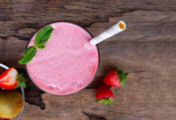 Strawberry smoothies juice beverage healthy the taste yummy In glass drink episode morning on wooden background from the top view.