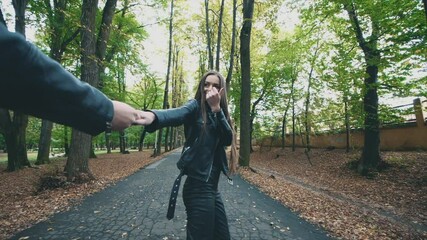 Young pretty happy woman is smiling in autumn park. Total black look. Slow motion. Copy space. 4K.
