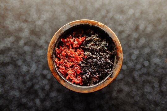 Bowl of the hookah is filled with tobacco mixed with different flavors for Smoking and leisure. Hookah tobacco smoke shisha relaxation. Close up top view image