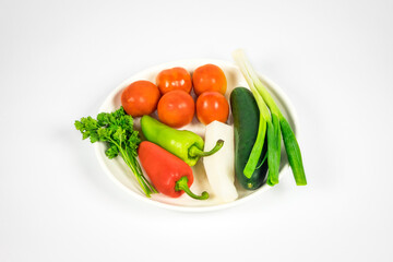 Vegetables isolated on a white background on the white plate ready for cooking.