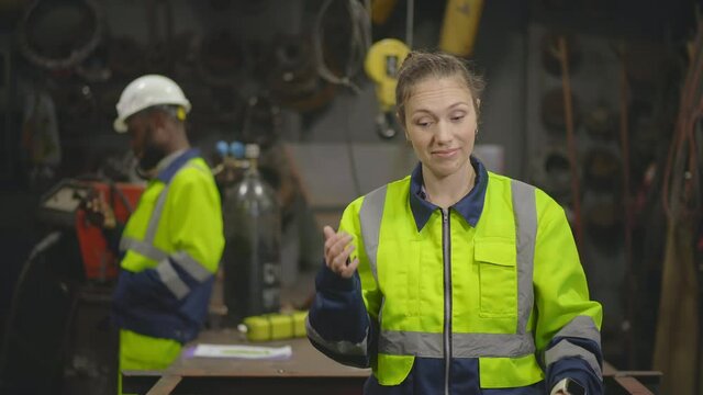 Tired woman engineer having migraine standing in workshop