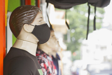 dressed mannequin model in street wearing protective mask during covid-19 pandemic