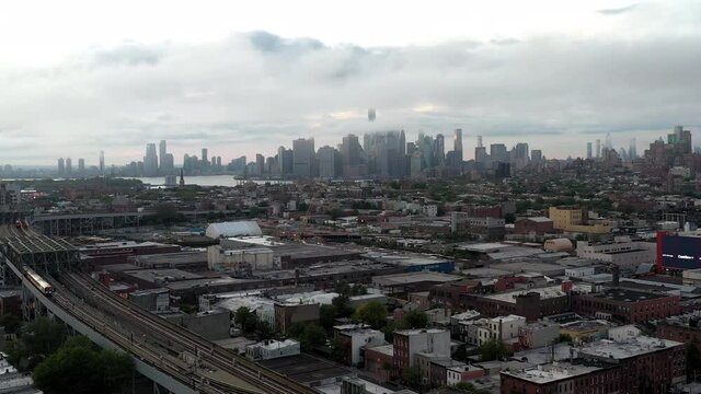 Brooklyn subway train pulling back Manhattan skyline smog dark clouds New York City cloudy NYC