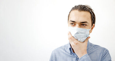 Sick man in the surgical facemask touching his face.