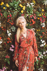 Woman in a red dress on a flower wall