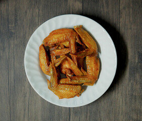 Fried chicken wings in white plate on wood
