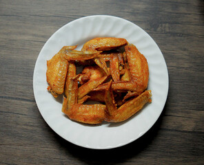 Fried chicken wings in white plate on wood