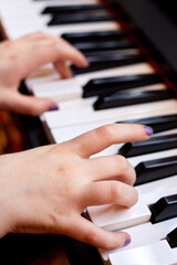 Obraz premium White Child's Hands Playing Piano Keyboard Viewed from Side