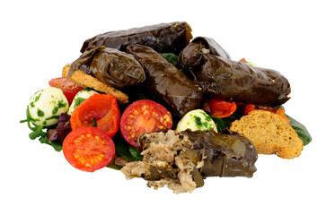 Stuffed vine leaves filled with rice and herbs with tomatoes and cheese balls isolated on a white background