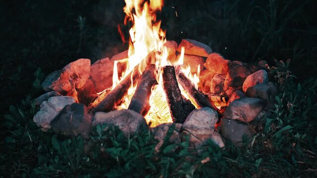 Graded shot of the campfire burning at night