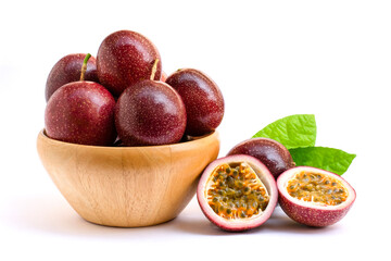 Close-up passion fruits ( Maracuya ) in wooden bowl and cut in half slice with green leaves isolated on white background . 