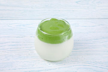 Dalgona Matcha Latte on a white wooden background.