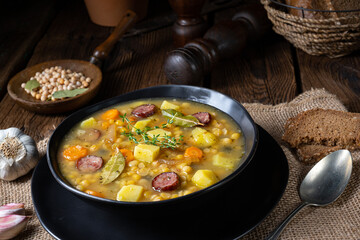 Rustic pea soup with bacon and sausages