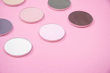 Pattern of eye shadows of different colors on a pink background