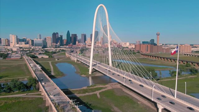 Aerial: Traffic crossing the Margaret Hunt Hill Bridge over the Trinity River & downtown Dallas. Texas, USA