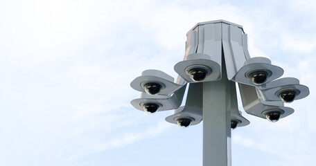 Modern public 360 degree CCTV cameras with bright sky background. Intelligent reccording cameras for monitoring all day and night. Concept of surveillance and monitoring with copy space.
