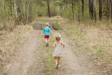 Obraz premium Brother and sister walk along the forest road