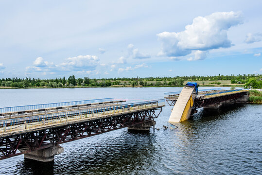 Destruction of bridge structures across the river with the collapse of sections into the water