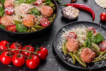 Delicious fresh pasta with meatballs, sauce, cherry tomatoes and basil