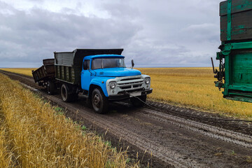 Fototapeta premium a truck with a broken trailer without a wheel broke another truck in the field in tow