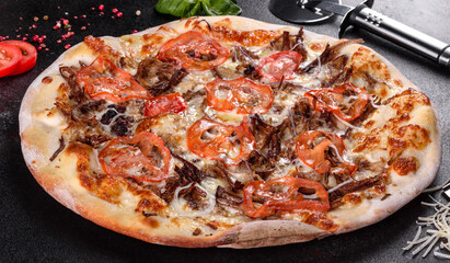 Fresh hot pizza with meat, mushrooms, cheese and tomatoes made in an oven